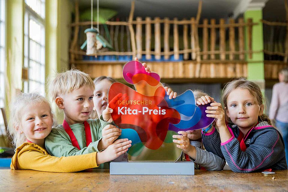 Deutscher KITA-Preis 2022 Kinder mit der Trophäe des deutschen KITA-Preises 2022