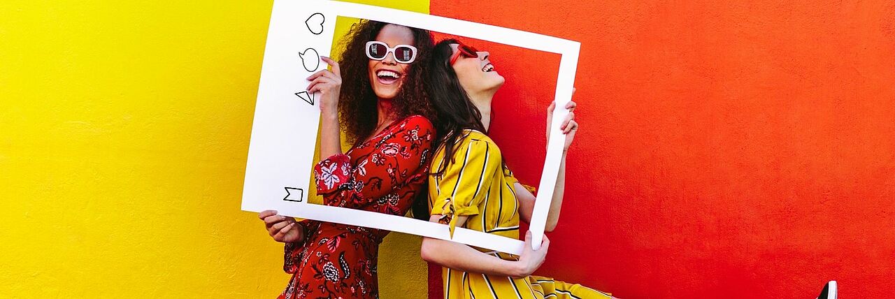 Zwei Frauen lachen vor einem Instagram Rahmen
